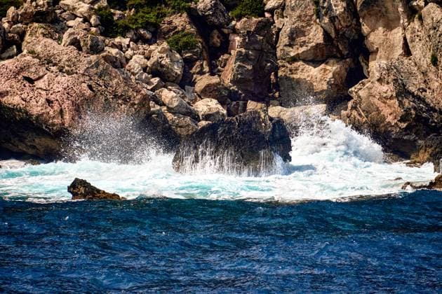 Creative Highlights World Menorca, Spain - June 13, 2025: Huge waves off Menorca crash against jagged rocks on a rocky coast, while spray splashes in all directions and the elemental force of the sea becomes visible *** Gewaltige Wellen vor Menorca krachen an schroffen Felsen einer felsigen Küste, während Gischt in alle Richtungen spritzt und die Urkraft des Meeres sichtbar wird.