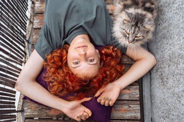 Creative Highlights Symbolbilder Porträt rothaarige, lockige junge Frau, die sich auf einem Balkon oder einer Terrasse entspannt red-haired curly young woman lying on wooden decking board on balcony enjoying doing nothing. there is big domestic cat nearby, spending time with pet (License=RF) ,model released, Symbolfoto Copyright: xZoonar.com LarysaxStefaniukx 23633476 ,model released, Symbolfoto ,property released