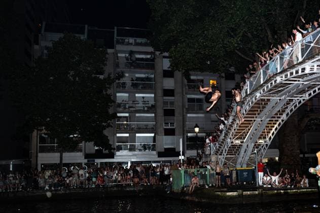 A Huge Crowd In The Streets Of Paris For la Fete De La Musique . Two people jump off the bridge at Canal Saint Martin during France s annual street music festival, the Fete de la Musique, in Paris, France, on June 21, 2025. Paris France  Copyright: xJeromexGillesx originalFilename: chobeaux-canicule250621_np7JM.jpg