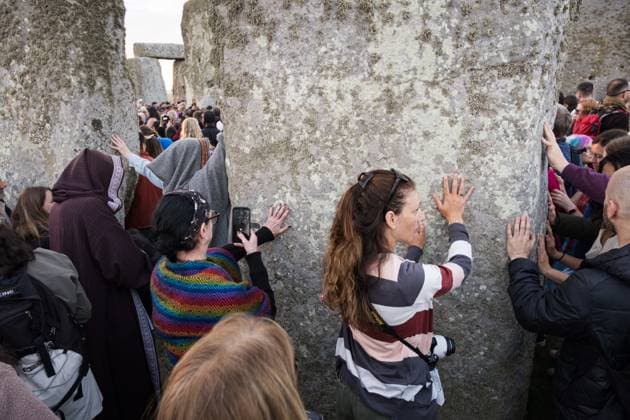 June 21, 2025, Wiltshire, United Kingdom: Spectators seen touching the monuments for blessings. Thousands of people attended the annual festival and watched sunrise celebrating the summer solstice at Stonehenge which signifies the end of spring. Wiltshire United Kingdom - ZUMAs197 20250621_aaa_s197_585 Copyright: xDanielxLaix