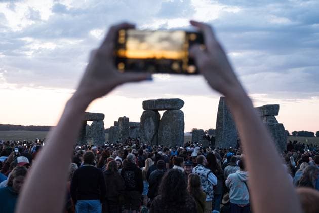 June 21, 2025, Wiltshire, United Kingdom: A spectator seen taking photos of the monuments before sunrise. Thousands of people attended the annual festival and watched sunrise celebrating the summer solstice at Stonehenge which signifies the end of spring. Wiltshire United Kingdom - ZUMAs197 20250621_aaa_s197_592 Copyright: xDanielxLaix