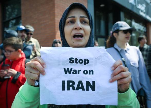 Woman With Israeli Flag Attacked During Edmonton Pro-Palestine Protest EDMONTON, CANADA JUNE 22: A woman holds a placard with words Stop War On Iran as members of the local Palestinian diaspora, joined by Iranian and other Middle Eastern Muslim protesters, along with local activists, gather on White Avenue in Edmonton for the Hands Off Palestine, Iran, Syria, Yemen, Lebanon protest on June 22, 2025, in Edmonton, Alberta, Canada. Edmonton Canada Copyright: xArturxWidakx originalFilename: widak-womanwit250622_npWe0.jpg