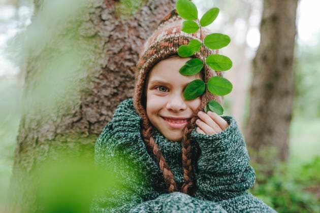 Creative Highlights Symbolbilder Happy girl in knit hat sitting by tree in forest model released, Symbolfoto, YTF00227