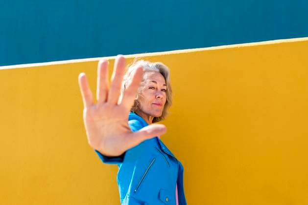 Creative Highlights Symbolbilder Confident woman gesturing in front of colored wall model released, Symbolfoto, OIPF02596
