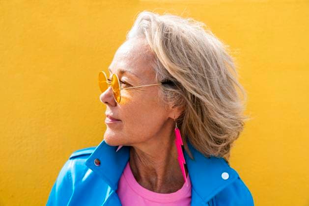 Creative Highlights Symbolbilder Contemplative woman wearing sunglasses in front of yellow wall model released, Symbolfoto, OIPF02642