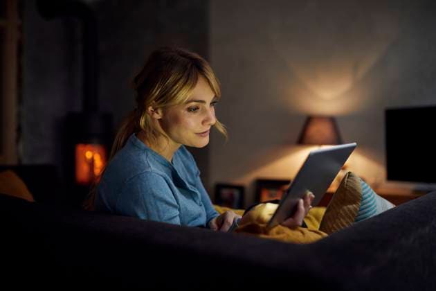 Woman relaxing at home with a tablet by the fireplace at night model released, Symbolfoto property released, RBF09950