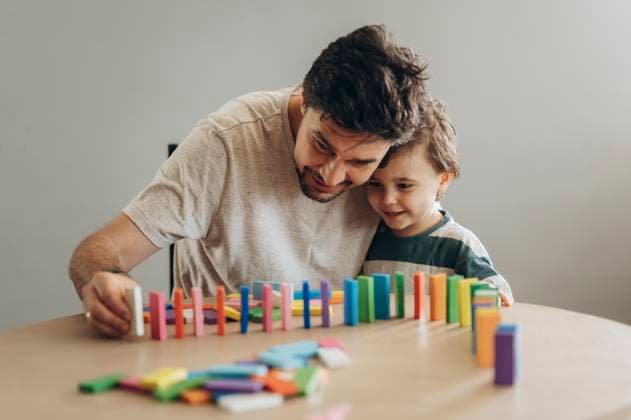 Father and son playing with colorful dominoes at home model released, Symbolfoto, ANAF04709