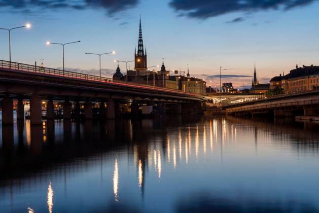 Illuminated view of Stockholm s Gamla Stan and Riddarholmen at blue hour with reflections on the water, TAMF04810
