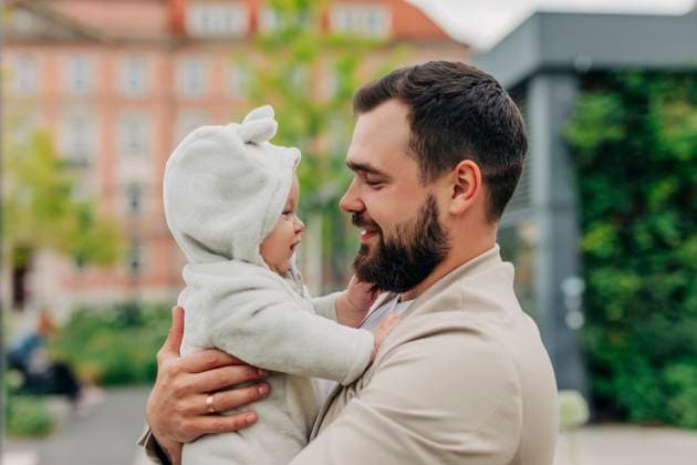 Father holding baby in arms outdoors in city setting model released, Symbolfoto, VSNF03417