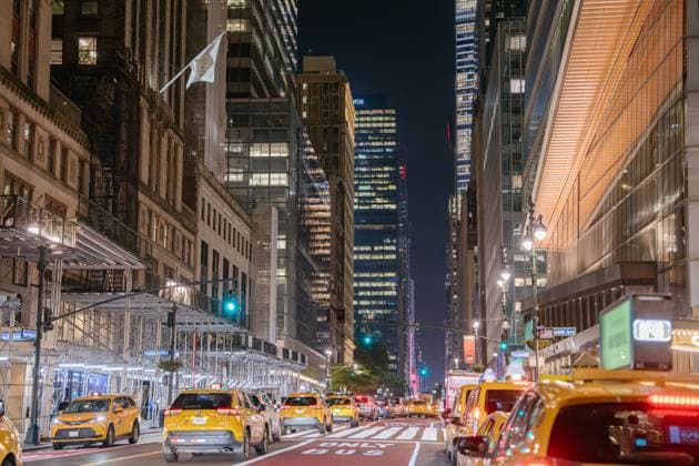 Nachtansicht von Midtown Manhattan mit gelben Taxis und Wolkenkratzern New York City, New York, USA - 07.30.2024: Yellow taxis move through a brightly lit Midtown Manhattan street at night. The scene captures glowing towers, busy traffic, scaffolding, and vibrant city life in New York City. (License=RM) Copyright: xZoonar.com DenysxKovtunx 23650528