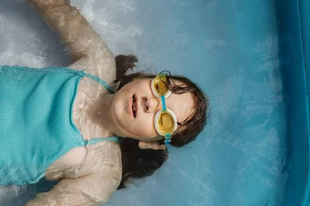 Creative Highlights Symbolbilder Child girl swimming in glasses in a pool on the back. Corby, England, United Kingdom R_JNDO250630-1775646-01 ,model released, Symbolfoto