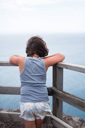 Creative Highlights Symbolbilder A young child leans on a wooden railing, gazing at the expansive ocean view in Fuerteventura, Spain, creating a serene and contemplative scene of coastal exploration. Model Released HodeiUnzueta_ID29104_888720_014 Copyright: xHodeixUnzuetax
