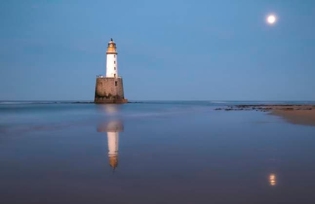 Twilight view of the historic Rattray Head Lighthouse in Scotland, with a calm sea and moonlight reflection. Model Released PacoFarero_ID29207_933719_025 Copyright: xPacoxFarerox