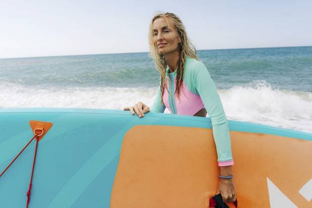 Eine junge, sportliche, blonde Frau steht am Strand und hält ein SUP Board Eine junge, sportliche, blonde Frau steht am Strand und hält ein SUP-Board Copyright: imageBROKER TITOVAxILONA ibxiqx14181897.jpg ,model released, Symbolfoto ,property released