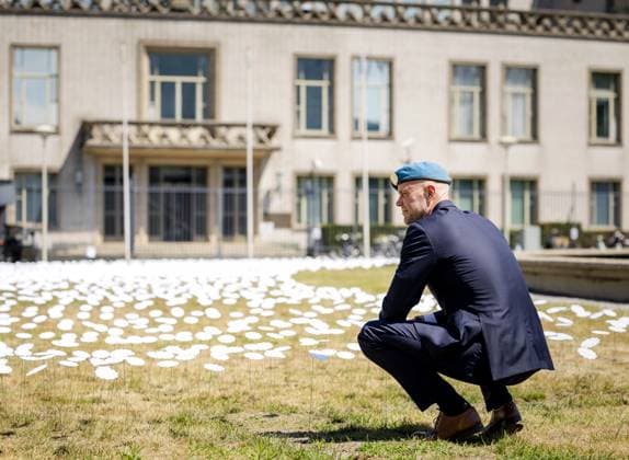 THE HAGUE - A Dutchbat III veteran places a flower during the unveiling of the site marker for a Srebrenica memorial on Churchill Square. The marker consists of bone white stone containing 8,372 pieces of tombstones from Bosnia. According to the initiators, there should be a monument to commemorate the genocide of more than 8,000 Bosnian Muslim men in Srebrenica, under the watchful eye of the Dutch UN peacekeeping force Dutchbat. The site marker is the first physical step toward a permanent national monument. ANP SEM VAN DER WAL netherlands out - belgium out  Copyright: xx x531346214x originalFilename: 531346214.jpg