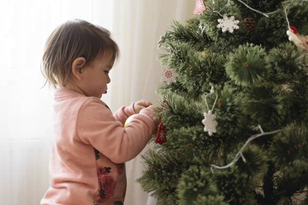 Mädchen im Kleinkindalter schmückt Weihnachtsbaum zu Hause. Dezember Traditionen für Kinder Toddler girl decorating christmas tree at home. December traditions for kids. Copyright: imageBROKER AlexandraxTroyan ibxiqx13807533.jpg ,model released, Symbolfoto ,property released