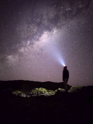Eine Person steht mit einer Stirnlampe unter einem Sternenhimmel und beobachtet die Milchstraße, La Réunion, Frankreich, Afrika A person stands stargazing with a headlamp under a starry sky and the Milky Way, La Réunion, France, Africa Copyright: imageBROKER PHILLIPxNEFF ibxpne14254487.jpg ,model released, Symbolfoto ,property released
