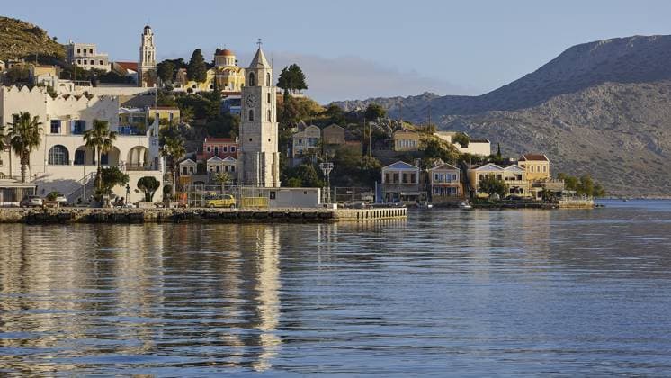 IMAGO Creative, Herbst, Reiseziel, Dodekanes, Griechische Inseln Küstenstadt mit einem Turm, Kirche, Berge im Hintergrund, ruhiges Wasser, Symi Stadt, Symi, Dodekanes, Griechische Inseln, Griechenland, Europa Coastal town with a tower, church, mountains in the background, calm water, Symi town, Symi, Dodecanese, Greek Islands, Greece, Europe Copyright: imageBROKER RalfxAdler ibxraa13828418.jpg