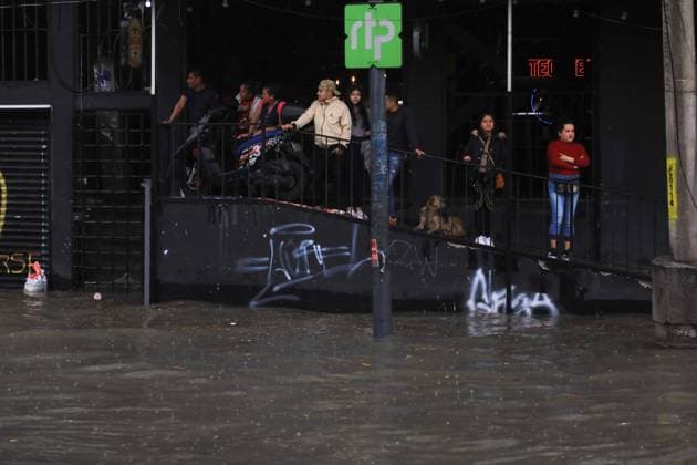 People take shelter in the entrance of a bar because the Ignacio Zaragoza causeway flooded in the Iztapalapa borough, after the storm that affected the east of the city due to heavy rains, leaving traffic disruptions for several hours. on July 15, 2025 in Mexico City, Mexico. Mexico City Mexico - ZUMAe321 20250715_zia_e321_069 Copyright: xIanxRoblesx