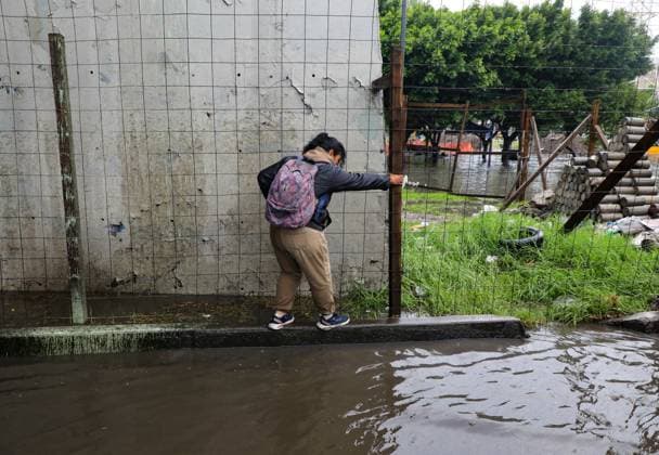 A woman tries to cross the flooded Ignacio Zaragoza road in the Iztapalapa borough, after the storm that affected the east of the city due to heavy rains, leaving traffic disruptions for several hours. on July 15, 2025 in Mexico City, Mexico. Mexico City Mexico - ZUMAe321 20250715_zia_e321_070 Copyright: xIanxRoblesx