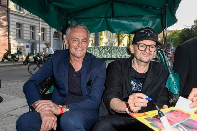 abb Robert Lohr and Milan Peschel Actors sit in the bicycle rickshaw as guests at the premiere of the film SchwarzeSchafe at the cinema in the Kultur Brauerei on July 15, 2025 in Berlin Berlin Germany