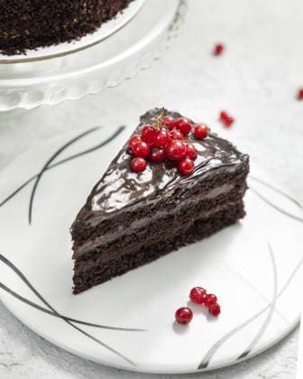 Köstliches Schokoladenkuchenstück mit roten Johannisbeeren und Schokoladenganache verziert Delicious chocolate cake slice decorated with red currant and chocolate ganache Copyright: imageBROKER Dr.xMartinxBaumgärtn ibxiqx14304263.jpg