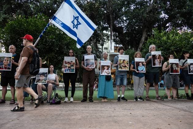 Israeli activists in Tel Aviv protest military targeting of Gaza women and children TEL AVIV, ISRAEL - JULY 19: A man walks with an Israeli flag in front of Israeli peace activists and foreign nationals gathering for a silent protest against the targeting of women, children, and civilians in Gaza, on July 19, 2025, in Tel Aviv, Israel. During the silent demonstration, protesters lined up along the street carrying photos of civilians killed in Gaza to draw attention to the ongoing attacks. Mostafa Alkharouf Anadolu Tel Aviv Israel. Editorial use only. Please get in touch for any other usage.  Copyright: x2025xAnadoluxMostafaxAlkharoufx