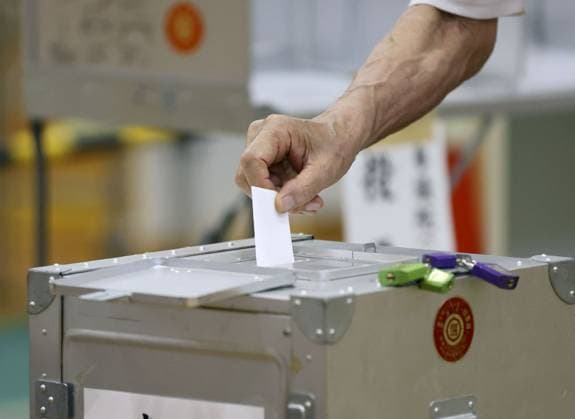 Upper house election in Japan A voter casts a ballot for Japan s House of Councillors election at a polling station in Tokyo on July 20, 2025.  A14AA0004731408P