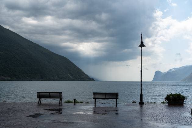Nago-Torbole, Trentino, Italy - July 21, 2025: Storm on Lake Garda with extreme rainfall and thunderstorms. Storm clouds and empty benches on the northern shore of Lake Garda *** Unwetter am Gardasee mit extremen Regenfall und Gewitter. Gewitterwolken und leere Sitzbänke am Nordufer vom Gardasee