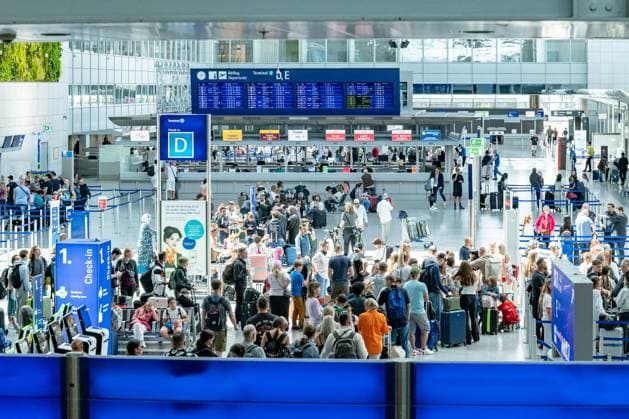 Großer Andrang am Check-in Terminal D, Flughafen Frankfurt 22.07.25, Frankfurt: Symbolfoto, Illustrationsbild, Symbolbild, Illustrationsfoto, Alltagsszene Weitwinkelaufnahme vom Check-in-Bereich im Terminal D des Frankfurter Flughafens. Hunderte Menschen warten in Schlangen an den Schaltern. Über den Köpfen ist eine große digitale Abflugtafel zu sehen, die internationale Flugverbindungen anzeigt. Die Szene dokumentiert eindrucksvoll das hohe Passagieraufkommen in Spitzenzeiten und den logistischen Ablauf im Luftverkehr. Frankfurt Hessen Deutschland *** Large crowd at check-in Terminal D, Frankfurt Airport 22 07 25, Frankfurt Symbol photo, illustration photo, symbol image, illustration photo, everyday scene Wide-angle shot of the Copyright: xW2Artx xThorstenxWagnerx