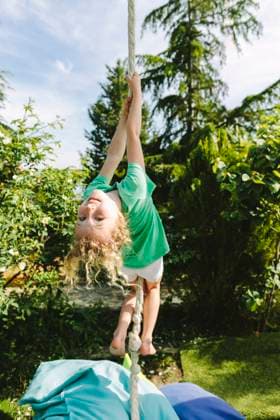 Creative Highlight Symbolbilder Child joyfully swinging upside down outdoors model released, Symbolfoto property released, SIF01356