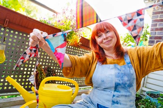 IMAGO Creative, Lifestyle, Feste im Garten #2 Smiling person decorates garden with bunting for joyful celebration at home model released, Symbolfoto property released, IHF02238