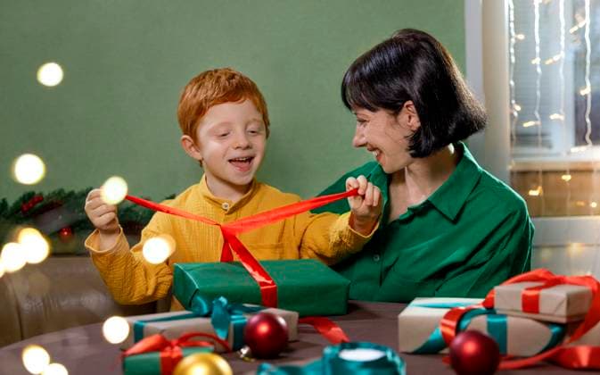 Mother and son happily packing Christmas gifts together at home model released, Symbolfoto, MBLF00922