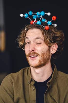 Creative Highlight Symbolbilder Playful sciengtist at home wearing molecule model as crown and winking model released, Symbolfoto property released, KNSF11594