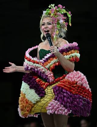 Her Universe founder Ashley Eckstein addresses the audience in a dress made with real flowers at the 11th Annual Her Universe Fashion Show during Comic-Con at the Seaport Ballroom of the Manchester Grand Hyatt in San Diego, California on Thursday, July 24, 2025. The fan-favorite event showcases work from designers across the country competing for the opportunity to design an exclusive apparel collection with Her Universe.  SDI20250724149 CHRISxCHEW