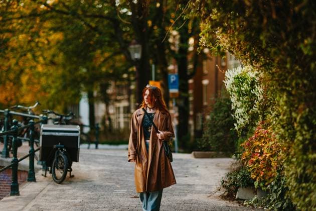 IMAGO Creative, Jahreszeit Herbst in der Stadt A woman enjoys a serene afternoon stroll through a charming Amsterdam street, surrounded by lush greenery and bicycles, showcasing the city quintessential ambiance. Model Released CamilleGirard_ID29202_933483_016 Copyright: xCamillexGirardx RECORD DATE NOT STATED