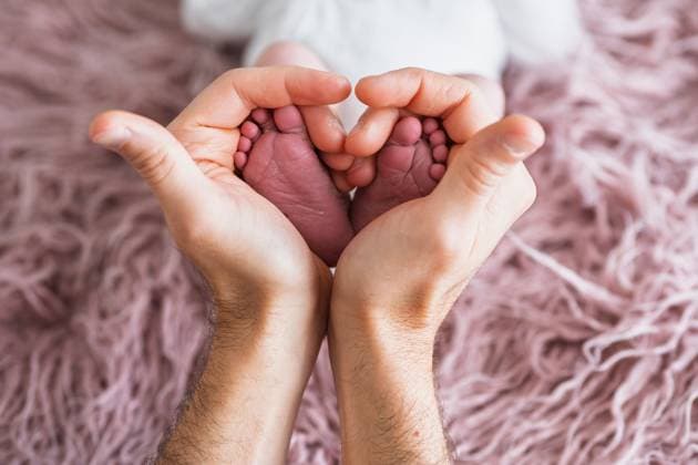 Close up of a father hands gently cradling his newborn baby tiny feet, capturing a tender moment of love and protection on a soft, textured background. Model Released HodeiUnzueta_ID30238_1019399_006 Copyright: xHodeixUnzuetax RECORD DATE NOT STATED
