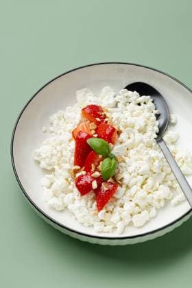 Cottage cheese with fresh strawberries on plate A delightful serving of creamy cottage cheese topped with fresh, juicy strawberries and a hint of mint leaves on a white plate, offering a delicious contrast in color Model Released JuliaKuvaldina_ID30036_1014111_007 Copyright: xJuliaxKuvaldinax