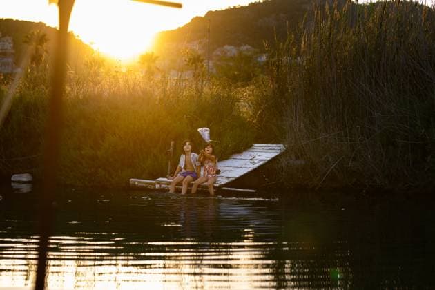 MR_ID27003_20116_LeoBosquetCarli.jpg, MR_ID27003_20106_MayaBosquetCarli.jpg Two children enjoy a serene evening fishing by a lake, surrounded by tall reeds and the warm glow of a setting sun. Tranquility and nature blend in perfect harmony. Model Released MagdalenaCarli_ID27003_779333_024 Copyright: xMagdalenaxCarlix