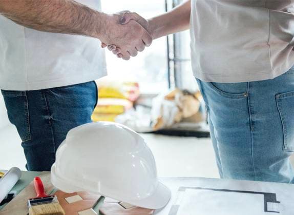 Ein Bauhelm, männliche und weibliche Hände, die sich die Hände schütteln. Ein Mann und eine Frau geben sich die Hand, um eine geschäftliche Vereinbarung oder einen Vertrag zu schließen. A construction helmet, male and female hands joined in a handshake. A man and a woman shake hands, concluding a business agreement or contract. A room with tools and construction equipment on table (License=RF) ,model released, Symbolfoto Copyright: xZoonar.com DashaxPetrenkox 23778291 ,model released, Symbolfoto ,property released