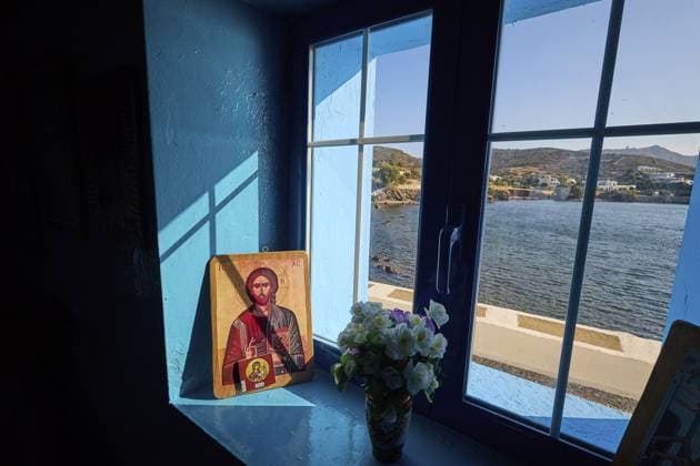 Ikone auf einer Fensterbank mit Blick aufs Meer, umgeben von blauem Licht und einem Blumenstrauß, Kapelle, Kirche, Agios Isidoros, Felseninselchen, Bucht von Gourna, Kokkali, Leros, Dodekanes, Griechische Inseln, Griechenland Icon on a windowsill overlooking the sea, surrounded by blue light and a bouquet of flowers, chapel, church, Agios Isidoros, rocky islet, Gourna Bay, Kokkali, Leros, Dodecanese, Greek Islands, Greece Copyright: imageBROKER RalfxAdler ibxraa14424199.jpg