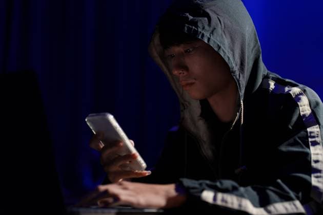 Hacker nutzt Smartphone für Phishing-Angriff und Datendiebstahl in dunkler Cyberumgebung Hacker operating smartphone to execute phishing scheme and steal sensitive information through cyber intrusion (License=RF) ,model released, Symbolfoto Copyright: xZoonar.com SirinarthxMekvorawuthx 23781500 ,model released, Symbolfoto ,property released