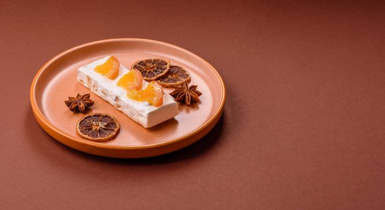 Nougat oder weißes Karamell mit Haselnüssen und Pistazien und Zitrusstücken. Weißer Nougat mit Nüssen Nougat oder weißes Karamell mit Haselnüssen und Pistazien und Zitrusstücken. Weißer Nougat mit Nüssen (License=RF) Copyright: xZoonar.com TetianaxChernykovax 23789600