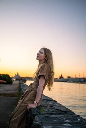 Creative Highlight Symbolbilder Woman enjoying golden hour on seaside promenade in Helsinki Helsinki, Uusimaa, Finland CR_PJJZ250724-1794639-01 ,model released, Symbolfoto