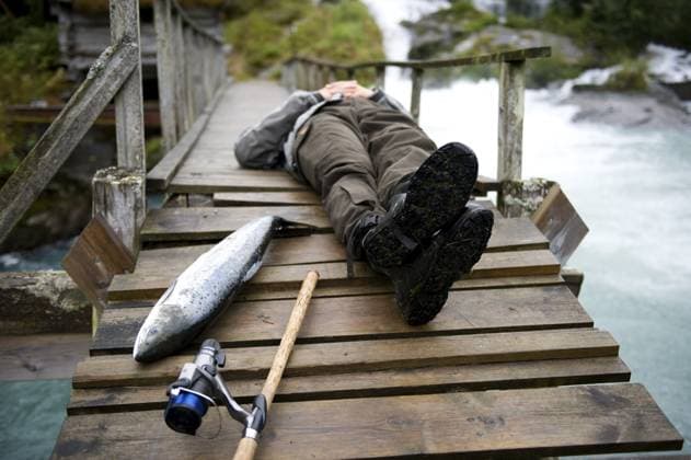 Mann auf Holzsteg liegend, nachdem er einen Fisch gefangen hat Man Lying on wooden pier after catching fish Copyright: imageBROKER ElisabethxHoiberg ibxhoi14450173.jpg ,model released, Symbolfoto ,property released