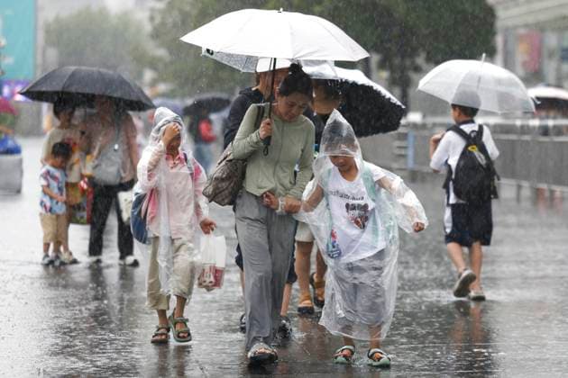 (250730) -- SHANGHAI, July 30, 2025 -- Travellers walk in the rain near Shanghai Railway Station in Shanghai, east China, July 30, 2025. Co-May, the eighth typhoon of this year, made landfall for the second time in east China s Shanghai Municipality on Wednesday afternoon after it made landfall in Zhejiang Province in early Wednesday morning, according to the Shanghai central meteorological observatory. The center of Typhoon Co-May (tropical storm level) made second landfall on the coast of Fengxian District, Shanghai around 4: 40 p.m. At the time of landfall, the maximum wind speed near the center was 23 meters per second, accompanied by a central minimum pressure of 978 hectopascals. ) CHINA-SHANGHAI-TYPHOON-CO-MAY-2ND LANDFALL (CN) W 