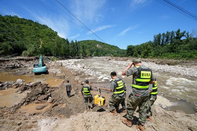 (250730) -- BEIJING, July 30, 2025 -- Rescuers deliver relief supplies on foot to road-blocked villages in Fengjiayu Town, Miyun District of Beijing, capital of China, July 30, 2025. Due to continuous heavy rainfall in recent days, hundreds of villages in multiple districts of Beijing have been affected. In some villages of Fengjiayu Town, Miyun District, the roads have not yet been restored. Relevant departments have organized multiple rescue forces including firefighters and militiamen to transport relief supplies on foot to the villages to ensure the living needs of the affected villagers. ) (SpotNews) CHINA-BEIJING-MIYUN-RAINSTORM-DAILY NECESSITIES (CN) JuxHuanzong 