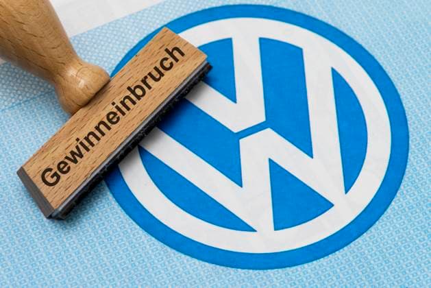 Gewinneinbruch bei VW Volkswagen Ein Holzstempel ist beschriftet mit Gewinneinbruch und liegt auf einer Aktie der Volkswagen AG - Symbolbild *** Profit slump at VW Volkswagen A wooden stamp is labeled with profit slump and lies on a Volkswagen AG share Symbolic image