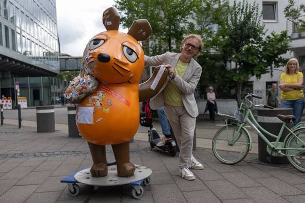 News Bilder des Tages Die WDR Maus geht in Kur - 01.08.2025 Leiter des WDR Kinderfernsehen Matthias KÖRNICH verabschiedet die Maus - Nach dem Brandanschlag wird das beschädigte Maus-Denkmal der Sendung mit der Maus vor dem WDR-Gebäude an der Mörsergasse in Köln in Kur geschickt. Ihre Brandstellen werden restauriert und möglichst bald wieder an ihren angestammten Platz zurück gebracht. Die angebrannte Skulptur ist mit Trostpflastern und mutmachenden Botschaften ihrer großen und kleinen Fans versehen. Deutschland *** The WDR Mouse goes on a cure 01 08 2025 Head of WDR Childrens Television Matthias KÖRNICH bids farewell to the Mouse After the arson attack, the damaged mouse monument of the program with the mouse in front of the WDR building on Mörs Copyright: xBonn.digitalx