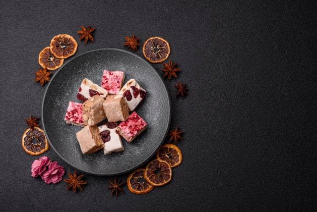 Nougat oder weißes Karamell mit Haselnüssen und Pistazien und Erdbeerstücken. Nougat mit Nüssen Nougat oder weißes Karamell mit Haselnüssen und Pistazien und Erdbeerstücken. Nougat mit Nüssen (License=RF) Copyright: xZoonar.com TetianaxChernykovax 23807155